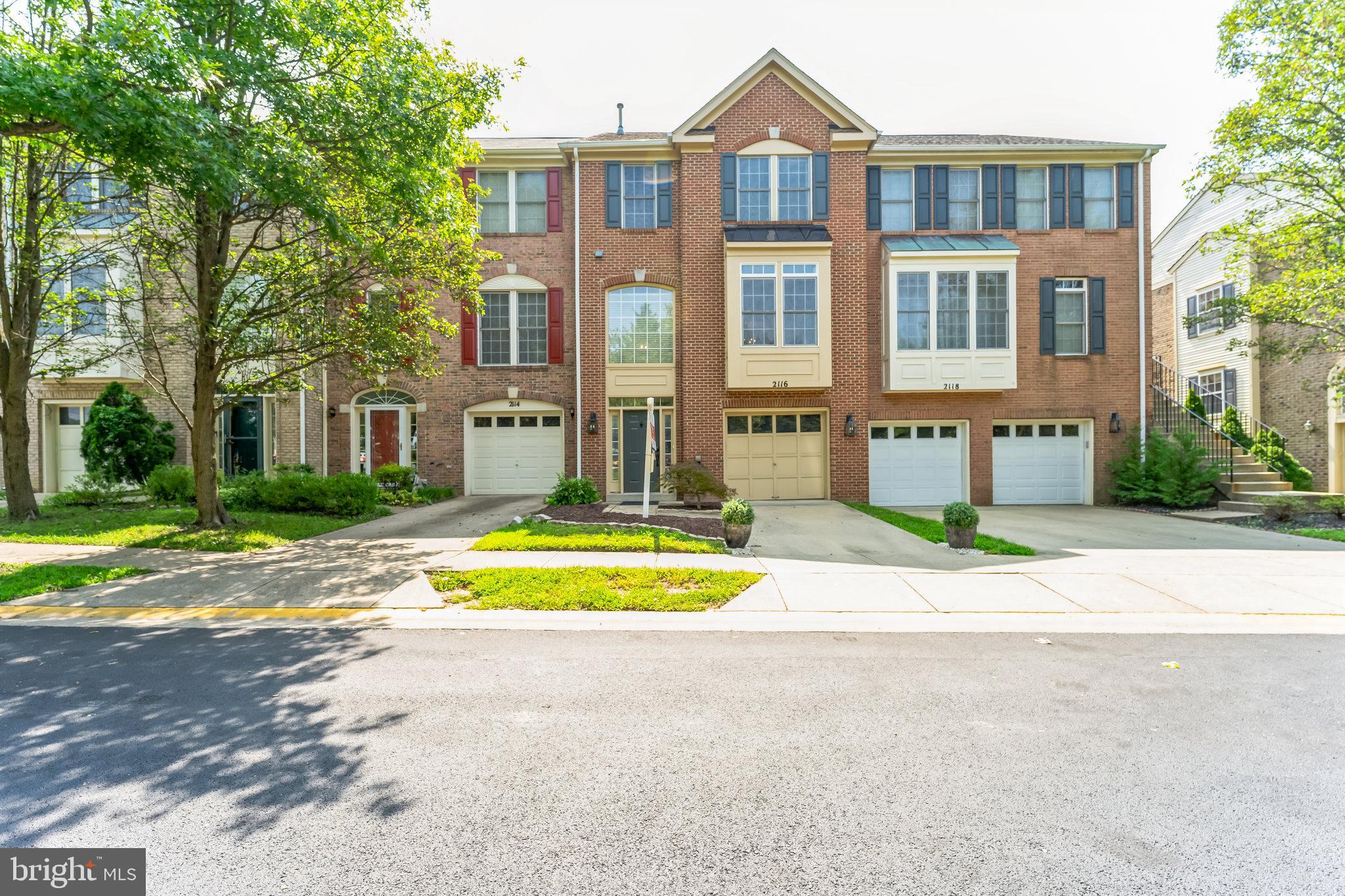 a front view of a house with a yard and trees