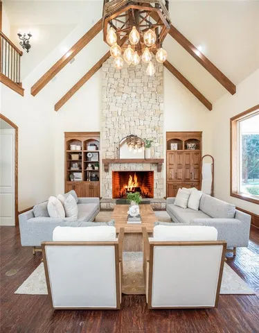 a living room with furniture a fireplace and a chandelier