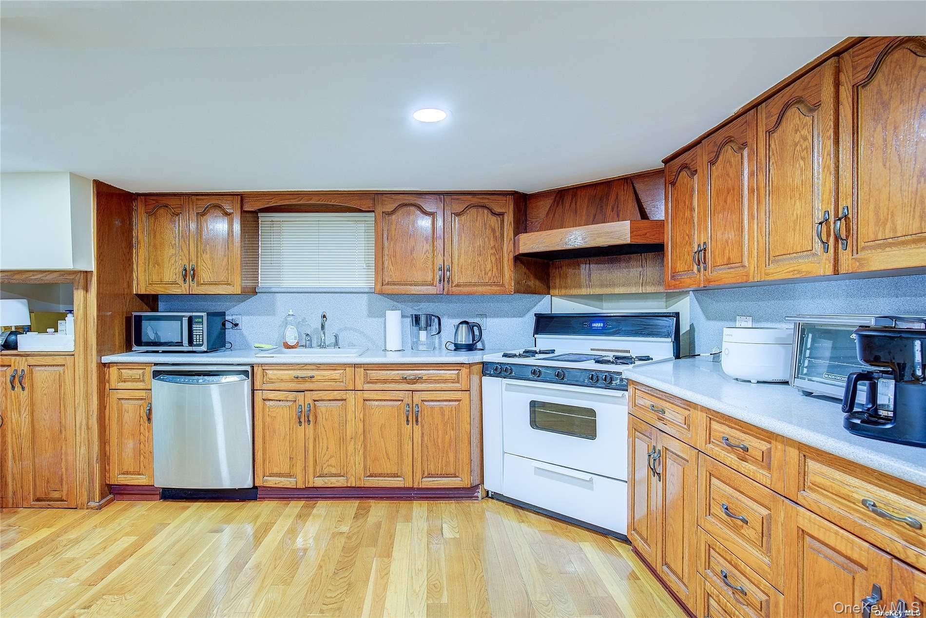 43-33 163rd Street Queens, NY 11358 - Photo 16 of 31 a kitchen with stainless steel appliances granite countertop a stove a sink and a white cabinets