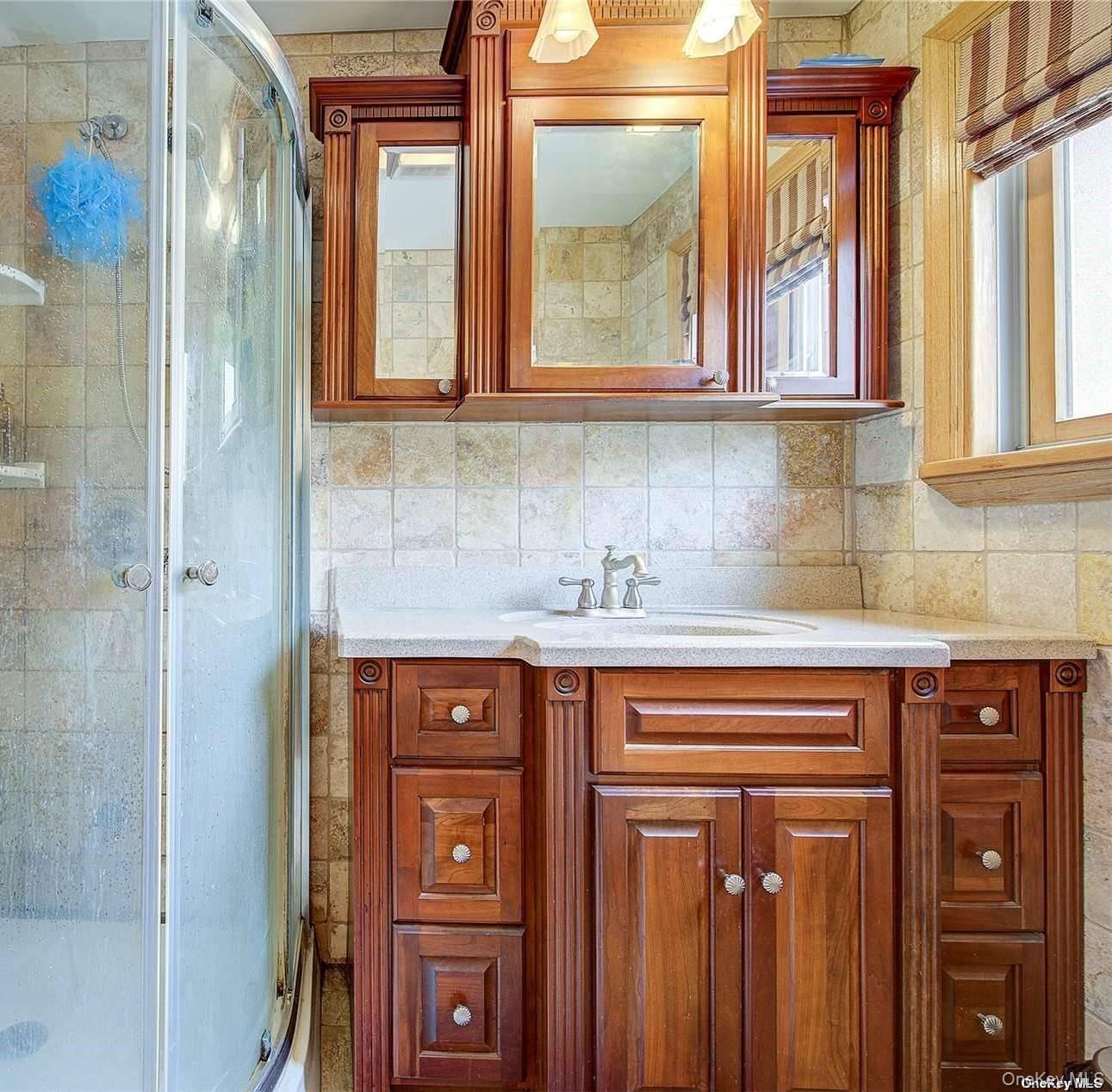 43-33 163rd Street Queens, NY 11358 - Photo 24 of 31 a bathroom with a sink a mirror and next to a window