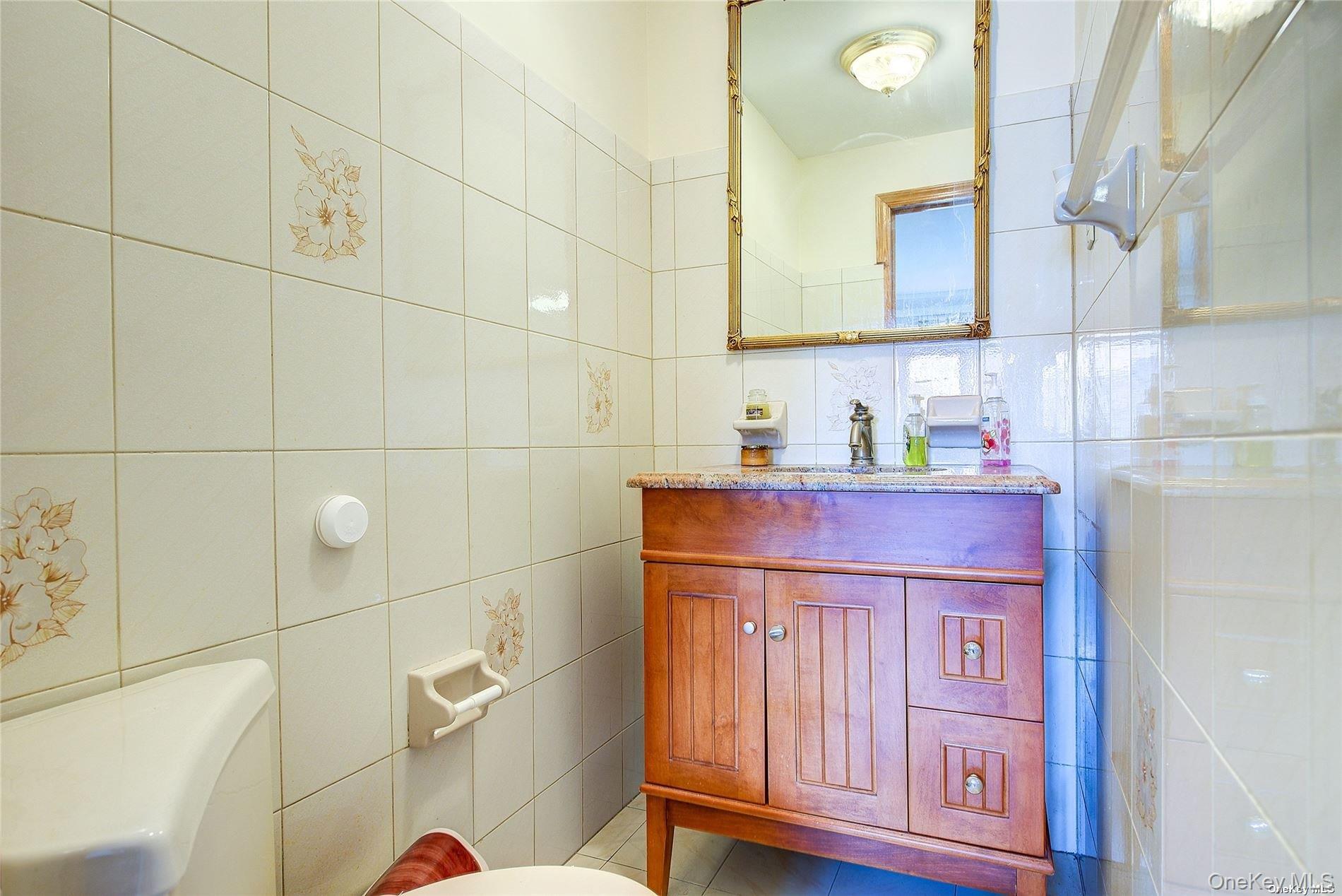 43-33 163rd Street Queens, NY 11358 - Photo 25 of 31 a bathroom with a sink a toilet and mirror