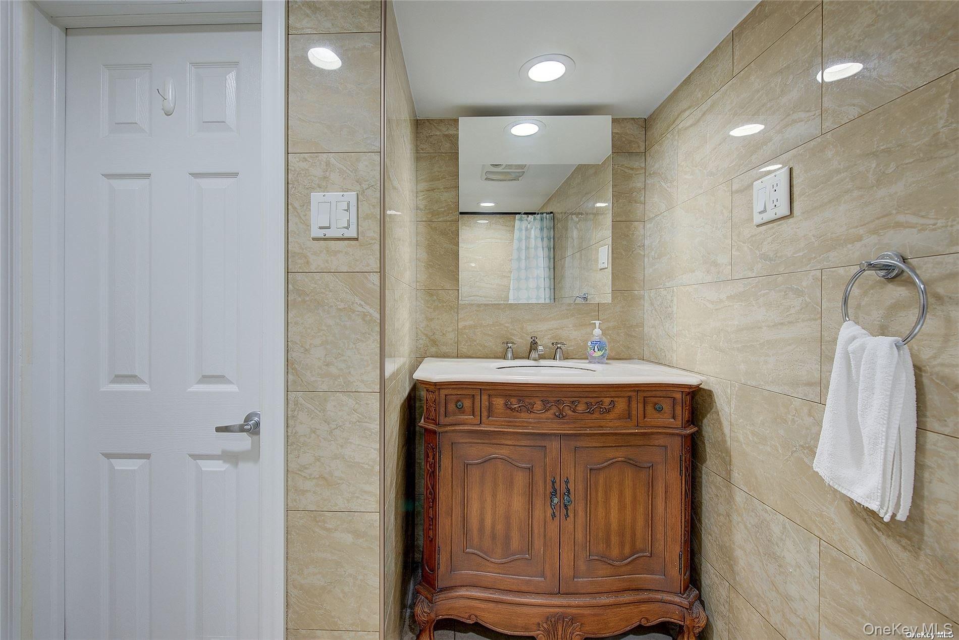 43-33 163rd Street Queens, NY 11358 - Photo 28 of 31 a bathroom with a sink and a mirror