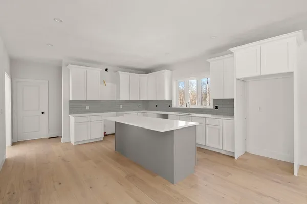 a kitchen with white cabinets and white appliances