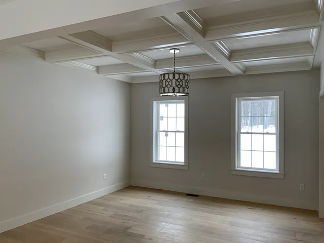 a view of empty room with fireplace and wooden floor