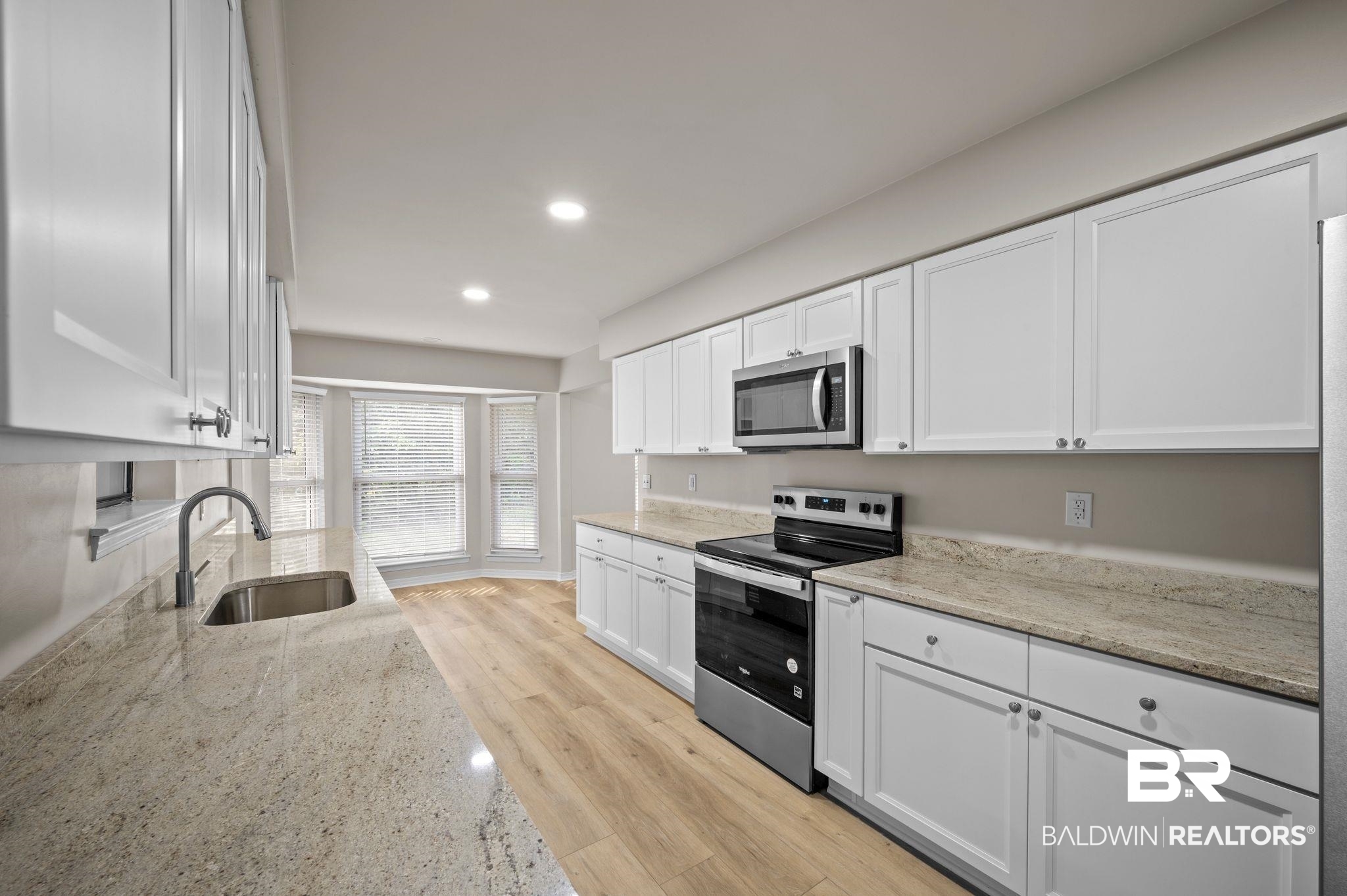 105 South Windgate Circle Daphne, AL 36526 - Photo 11 of 37 Kitchen featuring white cabinetry, light wood-style floors, a sink, and stainless steel appliances