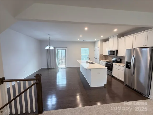 a view of kitchen with refrigerator microwave and wooden floor