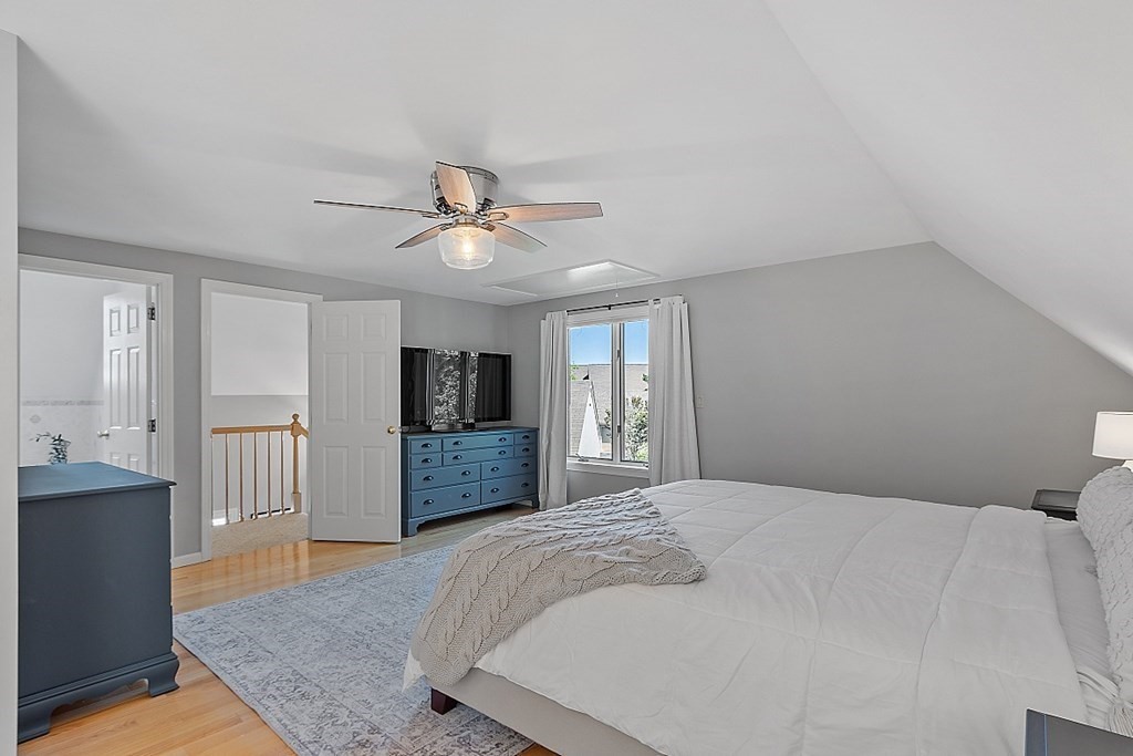 41 Quarry Ridge Lane, Unit 41 Rockport, MA 01966 - Photo 9 of 23 a bedroom with a large bed a chandelier and dresser