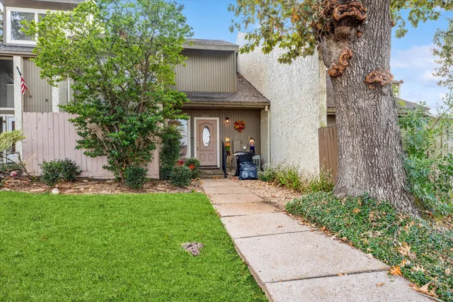 a front view of a house with a garden and trees