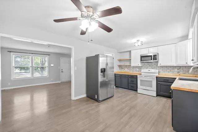a kitchen with granite countertop stainless steel appliances cabinets a sink and a window
