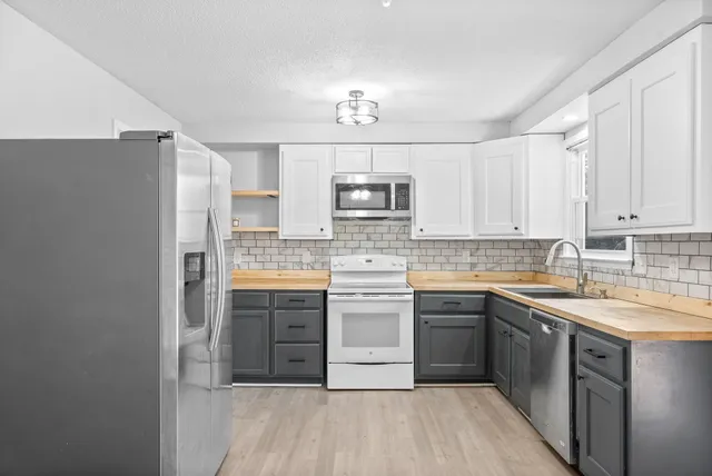 a kitchen with a sink a stove a refrigerator and cabinets