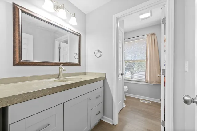 a bathroom with a granite countertop sink mirror and