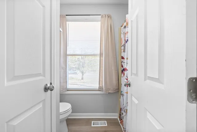 a bathroom with a toilet a sink and a window