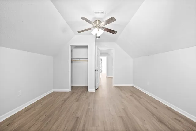 a view of a room with wooden floor and ceiling fan