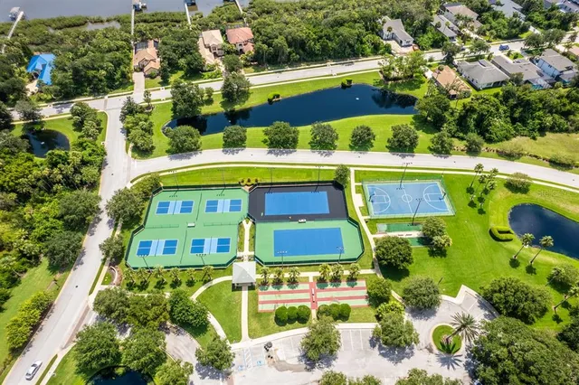 a view of white house with a swimming pool and a large tree