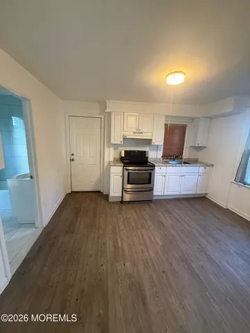 a view of a kitchen with wooden floor and electronic appliances