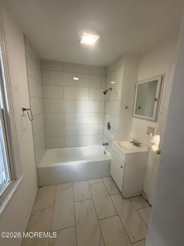 a bathroom with a bathtub a sink a toilet and a shower