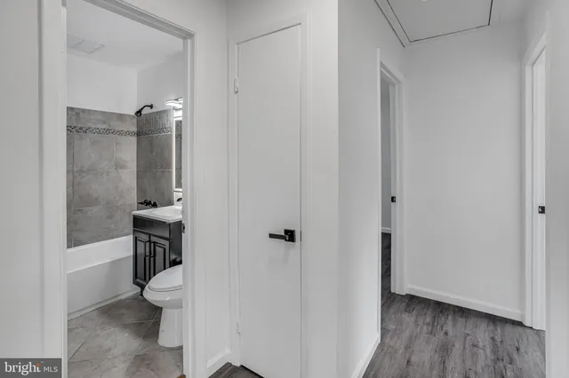 a bathroom with a granite countertop toilet a sink a mirror and shower
