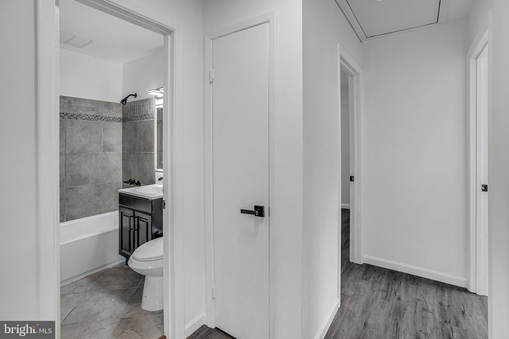 3412 North Beaumont Road Woodbridge, VA 22193 - Photo 12 of 34 a bathroom with a granite countertop toilet a sink a mirror and shower