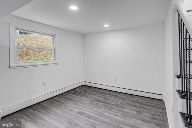 an empty room with wooden floor and window
