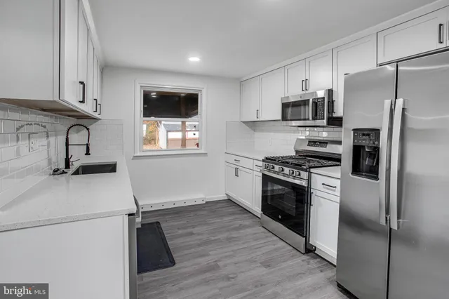 a kitchen with stainless steel appliances a refrigerator sink and microwave