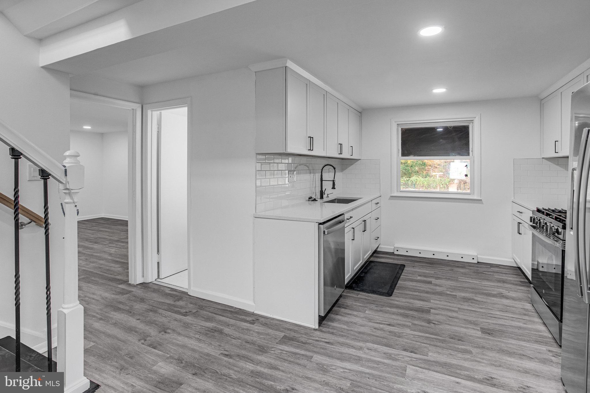 3412 North Beaumont Road Woodbridge, VA 22193 - Photo 21 of 34 a kitchen with stainless steel appliances granite countertop a refrigerator a sink dishwasher a stove and white countertops with wooden floor