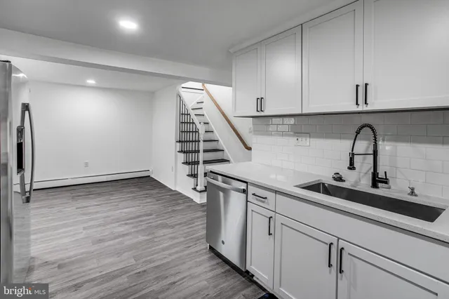 a kitchen with a sink and wooden floor