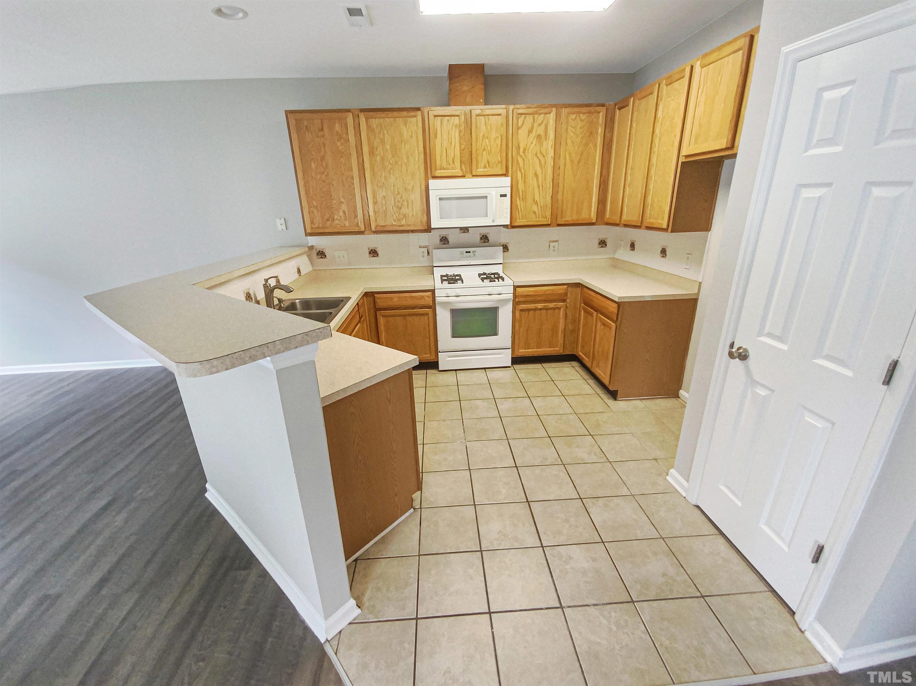 5105 Sandy Banks Road Raleigh, NC 27616 - Photo 11 of 15 a kitchen with a stove a sink dishwasher and a refrigerator