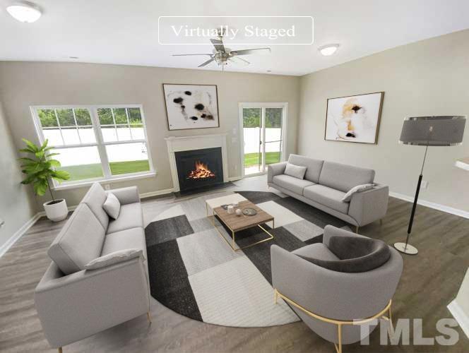 5105 Sandy Banks Road Raleigh, NC 27616 - Photo 2 of 15 a living room with furniture a fireplace and a large window