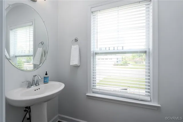 a bathroom with a sink a mirror and a window