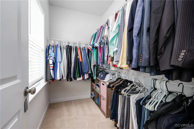 a view of walk in closet with clothes