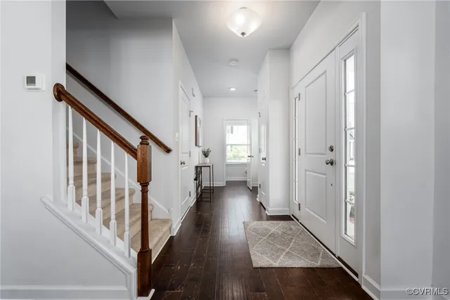 a view of a hallway with wooden floor and staircase