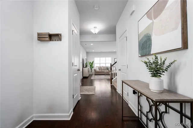 a view of a hallway with dining room and wooden floor
