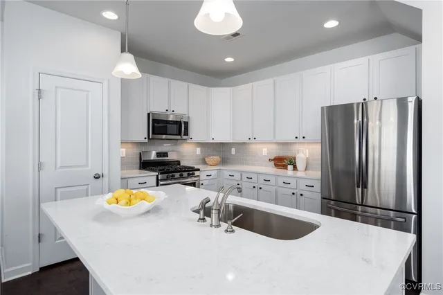 a kitchen with a refrigerator a stove a microwave and island with wooden floor