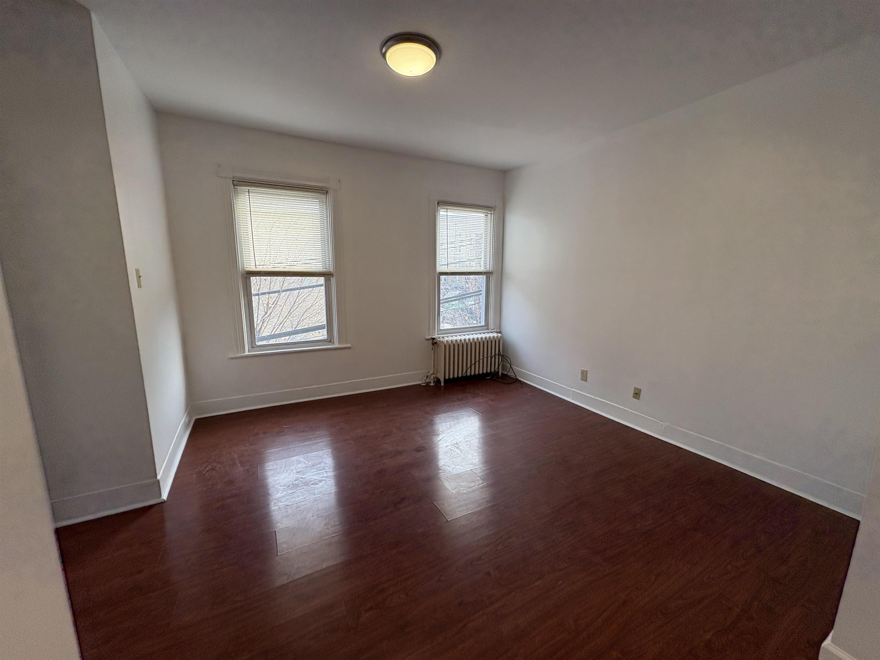 814 28th Street, Unit 2 Union City, NJ 07087 - Photo 8 of 12 an empty room with wooden floor and windows