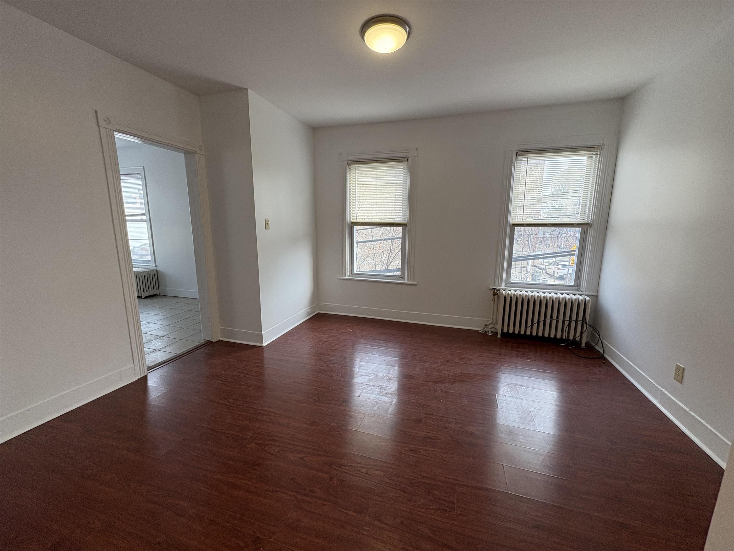 814 28th Street, Unit 2 Union City, NJ 07087 - Photo 10 of 12 an empty room with wooden floor and windows