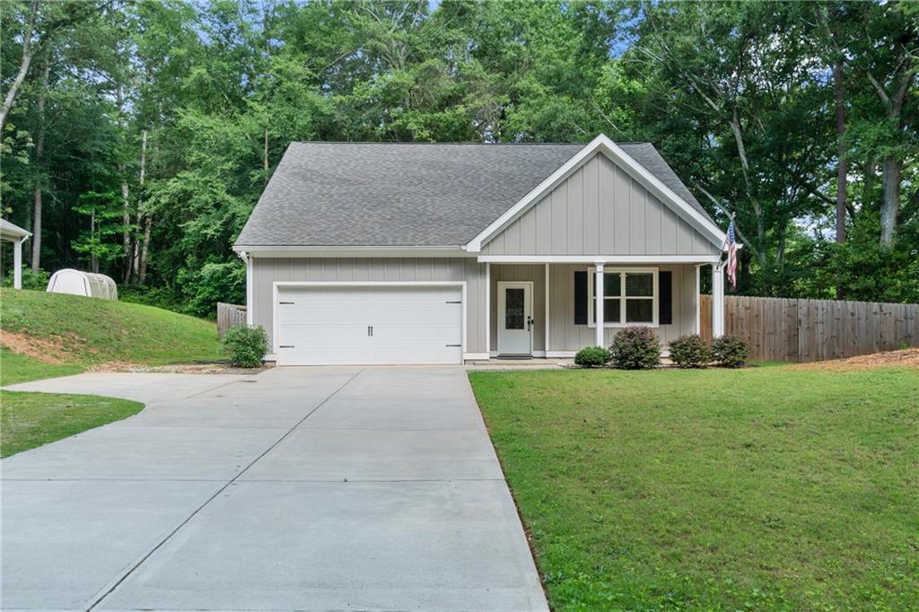 a front view of a house with a yard and trees