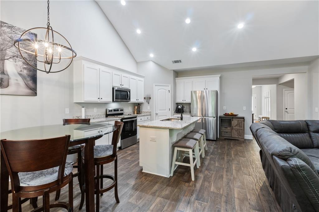 245 Hospital Road Commerce, GA 30529 - Photo 14 of 33 a living room with stainless steel appliances kitchen island granite countertop furniture and a wooden floor