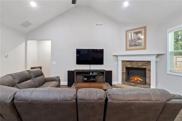 a living room with furniture a flat screen tv and a fireplace