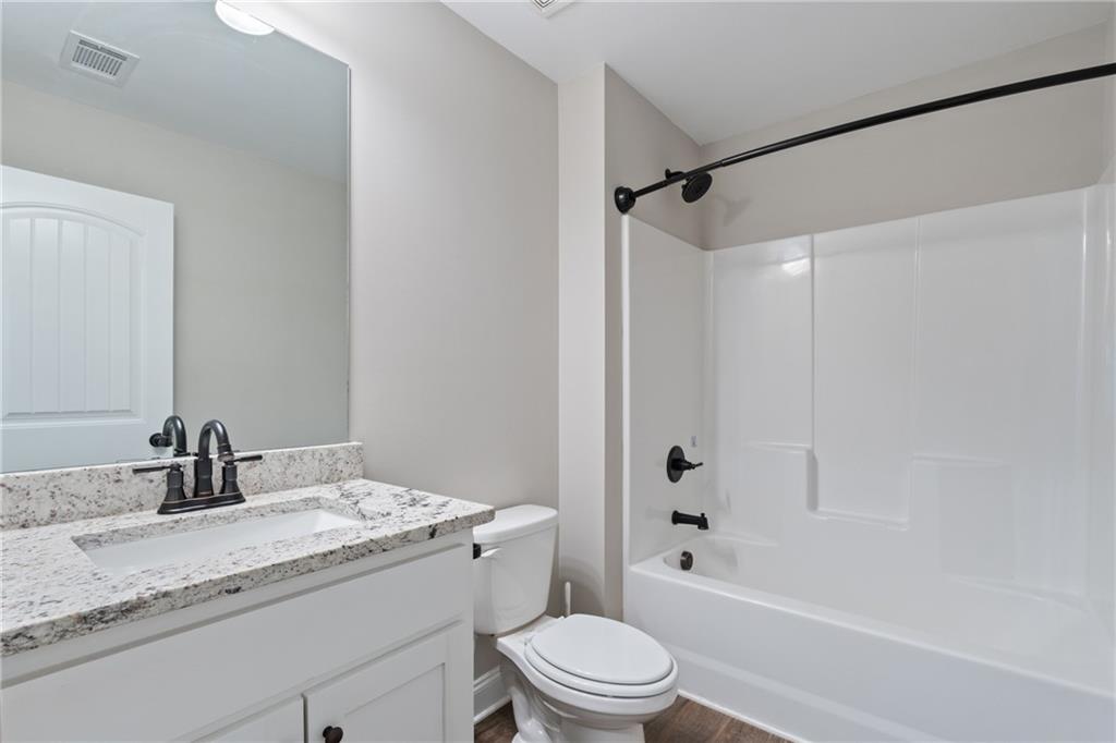 245 Hospital Road Commerce, GA 30529 - Photo 19 of 33 a bathroom with a granite countertop sink a toilet and shower