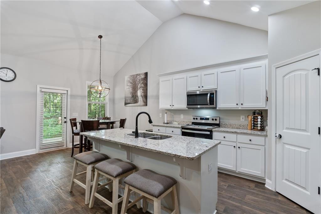 245 Hospital Road Commerce, GA 30529 - Photo 3 of 33 a kitchen with granite countertop a sink chairs and refrigerator