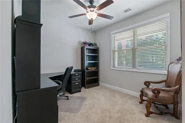 a view of a workspace with furniture and a window