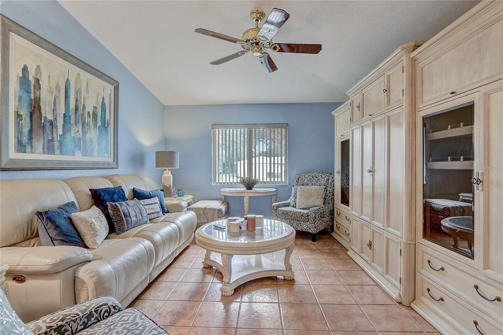 10031 Southwest 62nd Circle Ocala, FL 34476 - Photo 11 of 25 a living room with furniture a chandelier and a window