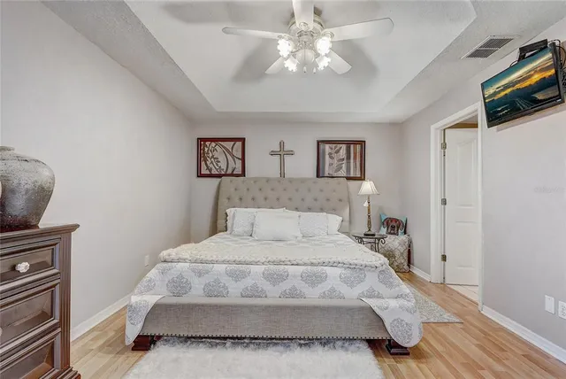 a spacious bedroom with a bed and a chandelier
