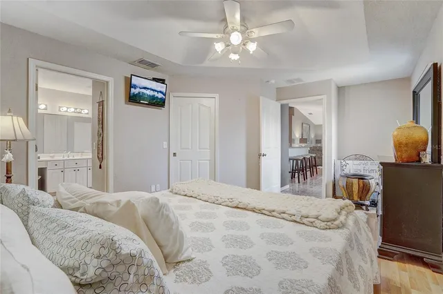 a bedroom with a bed chandelier and a window