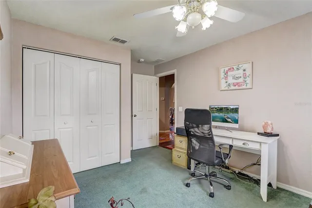 a view of a workspace with furniture and a window