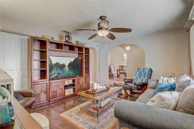 a living room with furniture ceiling fan and a large window