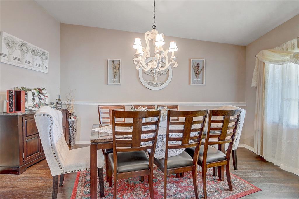 10031 Southwest 62nd Circle Ocala, FL 34476 - Photo 6 of 25 a dining room with furniture a rug and wooden floor