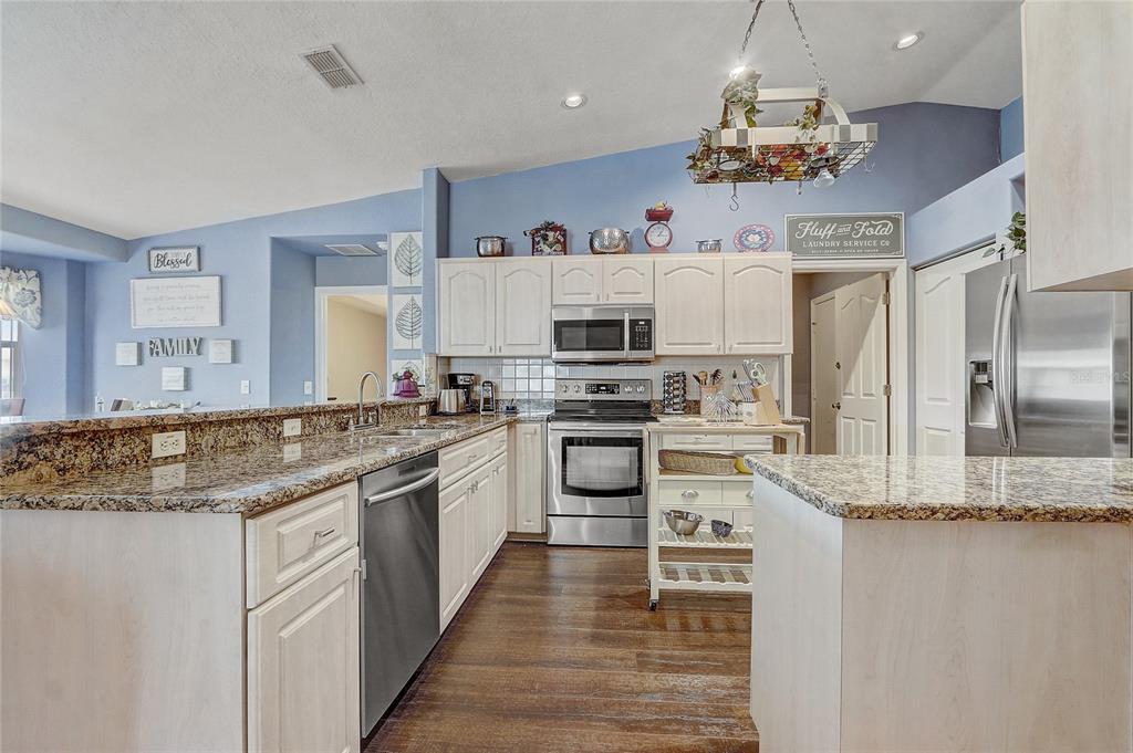 10031 Southwest 62nd Circle Ocala, FL 34476 - Photo 7 of 25 a kitchen with stainless steel appliances granite countertop a sink and cabinets