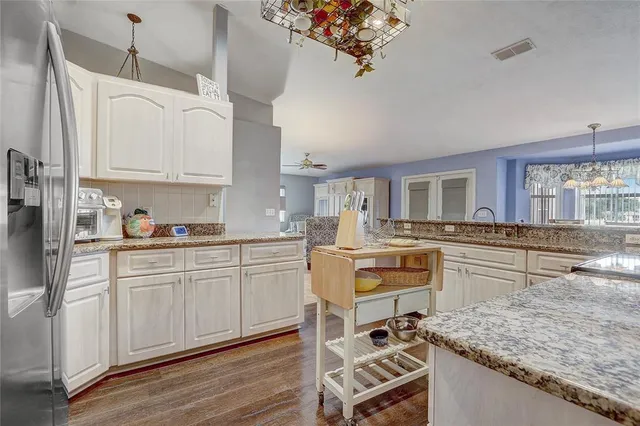 a kitchen with white cabinets and counter space
