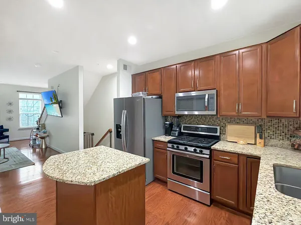 a kitchen with stainless steel appliances a stove a sink refrigerator and a microwave
